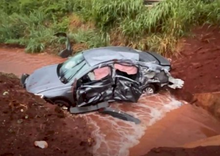 Carro é jogado em vala após acidente envolvendo um ônibus escolar durante chuva forte